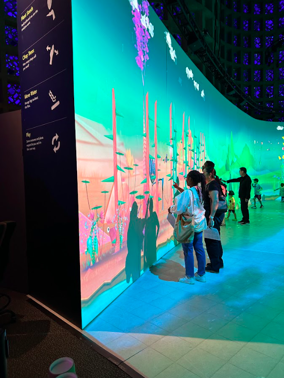 Students looking at Connected Worlds large video screen